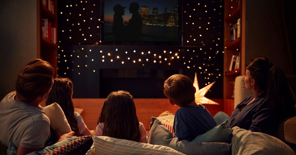photo of a family sitting on the couch gathered around a tv
