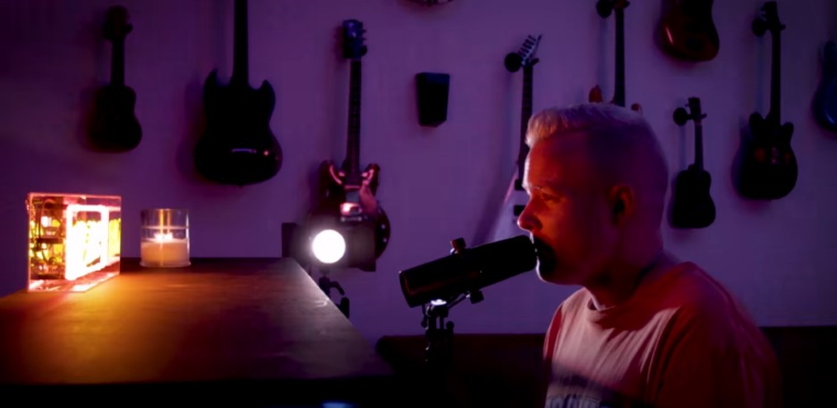 photo depicts a muscian singing at a piano from the video