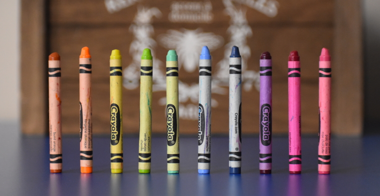 photo of different coloured crayons standing up in a row on a table