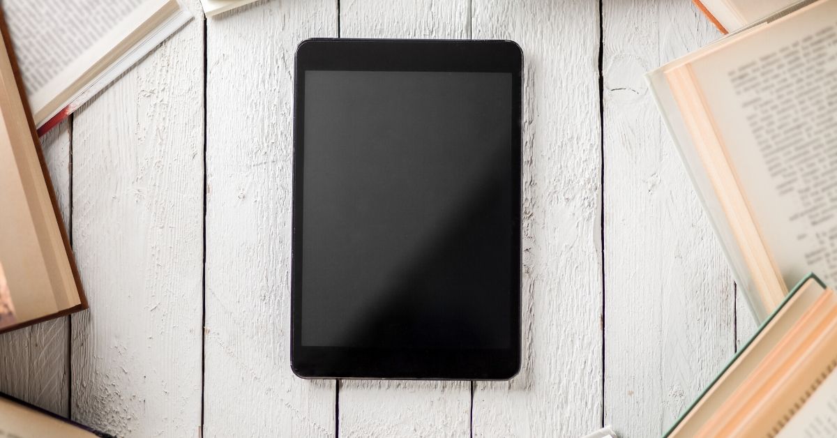 photo of a tablet surrounded by books, maybe the new format of books after COVID-19