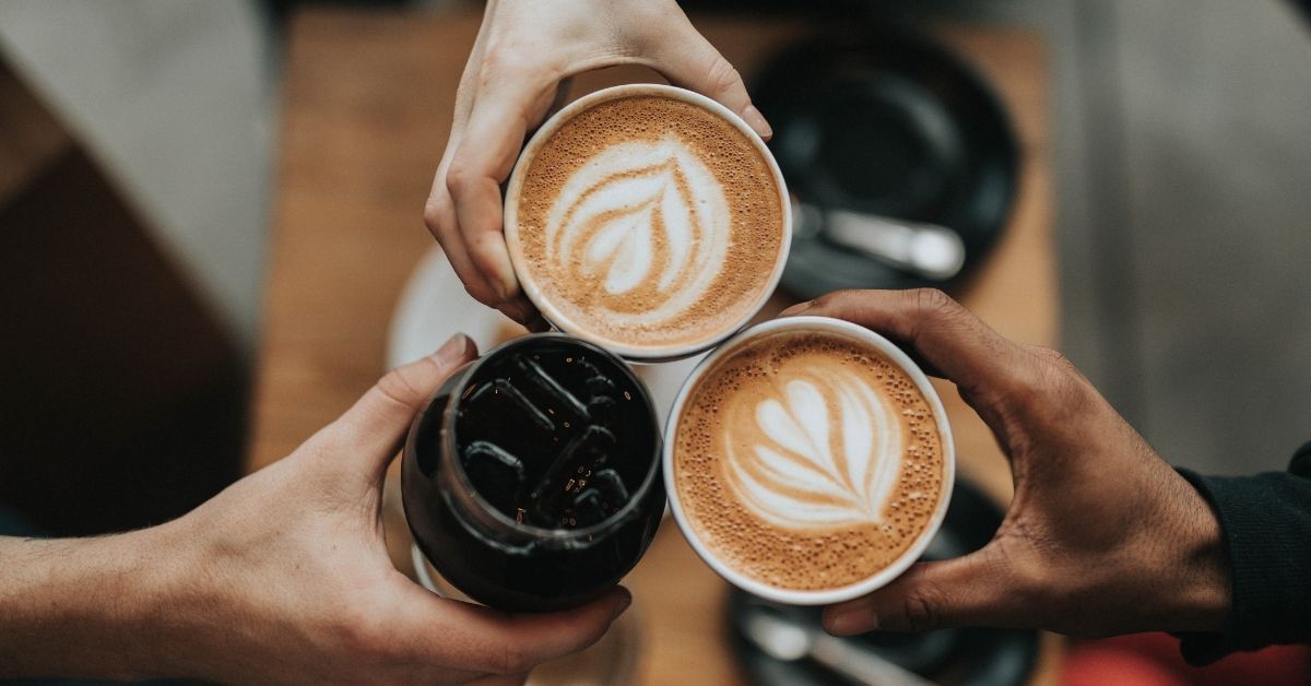 3 people holding coffee cups